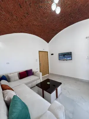 a living room with a white couch and a table at Sunrise Apartment in Hurghada