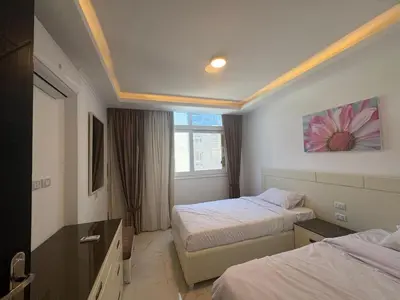 a hotel room with two beds and a window at Cozy one bedroom in a compound with beach ac in Hurghada