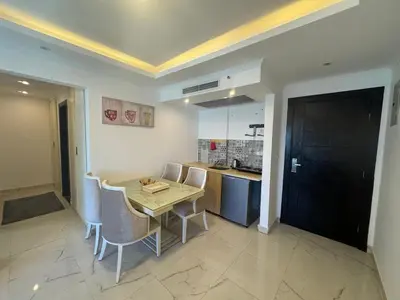 a kitchen with a table and chairs in a room at Cozy one bedroom in a compound with beach ac in Hurghada
