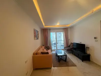 a living room with a couch and a tv at Cozy one bedroom in a compound with beach ac in Hurghada