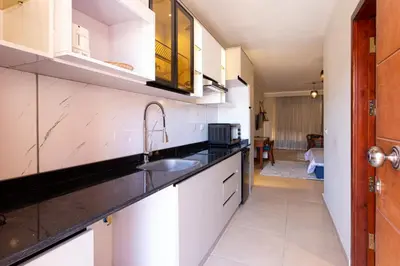 a kitchen with white cabinets and a sink at Cozy Studio 1st Avenue South Side in Hurghada
