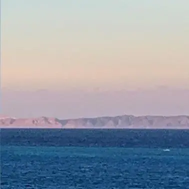a large body of water with mountains in the background at Hurghada mit Charme in Hurghada
