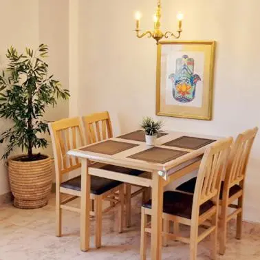 a dining room table with chairs and a potted plant at Hurghada mit Charme in Hurghada