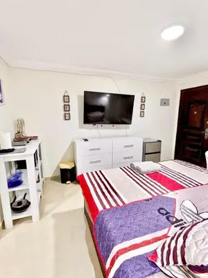a bedroom with two beds and a flat screen tv at Fanta Sea Studio with private jacuzzi - Al Ahyaa in Hurghada