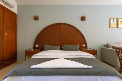 a bedroom with a large bed with a wooden headboard at Studio in a touristic area - Al mamsha in Hurghada