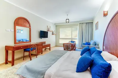 a bedroom with a large bed with blue pillows on it at Studio in a touristic area - Al mamsha in Hurghada