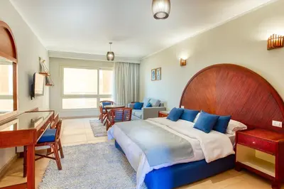 a bedroom with a large bed and a desk at Studio in a touristic area - Al mamsha in Hurghada