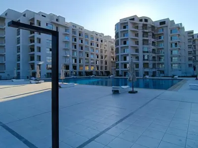 a large apartment complex with a swimming pool and buildings at Vitamin Sea, Beach Front Central Free Wi-Fi in Hurghada