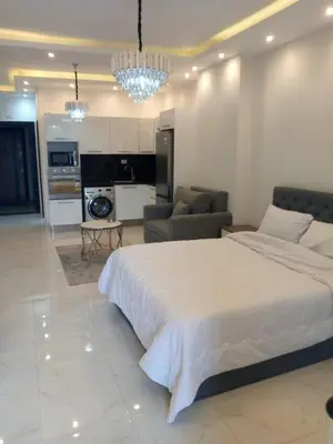 a bedroom with a large bed and a living room at الغردقه in Hurghada