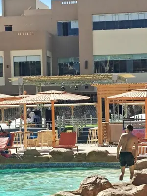a man walking in the water in a swimming pool at Studio in elkarma resort & aqua park in Hurghada