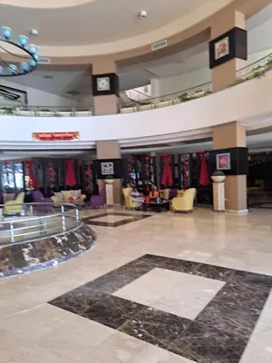 a lobby of a shopping mall with clocks on the ceilings at Studio in elkarma resort & aqua park in Hurghada