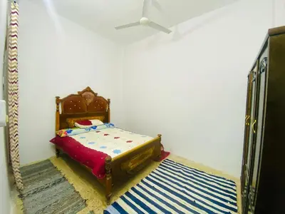 a small bedroom with a bed and a rug at Pharaoh apartment 2 in Luxor