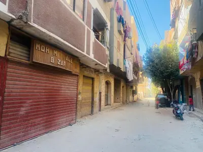 an alley with two garage doors and a motorcycle on a street at Pharaoh apartment 2 in Luxor