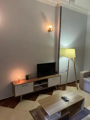 a living room with a television and a table at Cozy Retreat by The Sea in Safaga