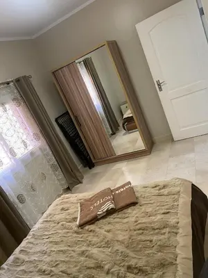 a bedroom with a bed and a large mirror at Home from Home Al Dora Residence in Hurghada