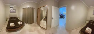 a room with two beds and a mirror at Home from Home Al Dora Residence in Hurghada