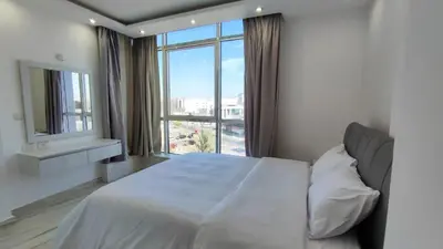 a bedroom with a white bed and a large window at Stylish Sunny Central 1BR Apartment Hurghada in Hurghada