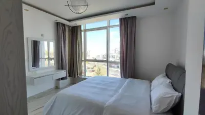 a bedroom with a white bed and a large window at Stylish Sunny Central 1BR Apartment Hurghada in Hurghada