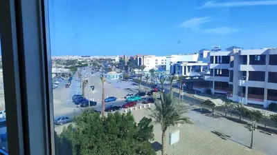 a view from a window of a city street with cars at Stylish Sunny Central 1BR Apartment Hurghada in Hurghada
