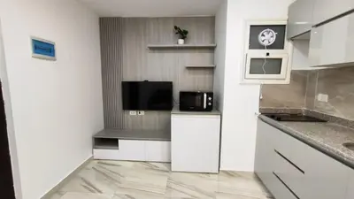 a kitchen with white cabinets and a microwave at Stylish Sunny Central 1BR Apartment Hurghada in Hurghada