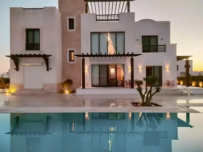 a villa with a swimming pool in front of a house at Stay at elgouna with private heated pool villa in Hurghada