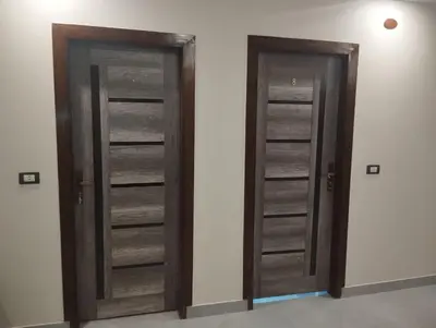 two wooden doors in a room with a wall at City centre Nile Breeze Aswan in Aswan