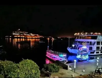 a ferry boat is docked in the water at night at City centre Nile Breeze Aswan in Aswan