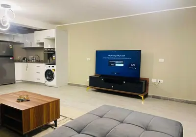 a living room with a couch and a large screen tv at Apartment 3 Bedrooms Bali BR C1-D with Private Pool at Bali in Hurghada