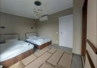 a bedroom with two beds and a chandelier at Apartment 3 Bedrooms Bali BR C1-D with Private Pool at Bali in Hurghada