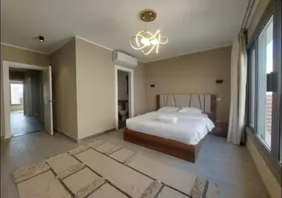 a large bedroom with a bed and a chandelier at Apartment 3 Bedrooms Bali BR C1-D with Private Pool at Bali in Hurghada