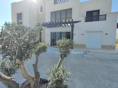 a white building with trees in front of it at Ancient Sand villa at Elgouna with private heated pool in Hurghada
