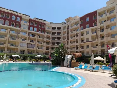 a swimming pool in front of a large building at Oscar luxury N109Free WI-FI in Hurghada