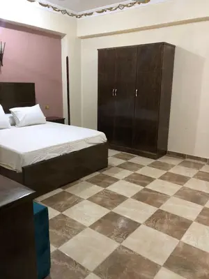 a bedroom with a bed and a checkered floor at Habu Garden Apartment in Luxor