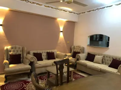 a living room with couches and chairs and a table at Habu Garden Apartment in Luxor