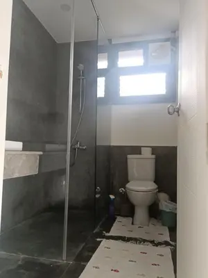 a bathroom with a toilet and a glass shower at Bali-Style 1BR 10 Min 2 Downtown in Hurghada