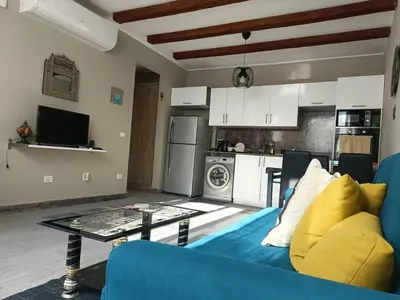 a living room with a blue couch and a kitchen at Bali-Style 1BR 10 Min 2 Downtown in Hurghada