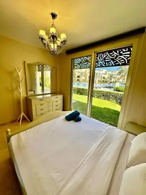 a bedroom with a large bed and a large window at 2 Bedrooms Ground Floor Pool view in Mangroovy Residence in Hurghada
