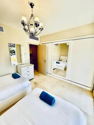 a bedroom with two beds and a large mirror at 2 Bedrooms Ground Floor Pool view in Mangroovy Residence in Hurghada