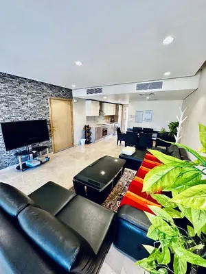 a living room with black leather furniture and a flat screen tv at 2 Bedrooms Ground Floor Pool view in Mangroovy Residence in Hurghada
