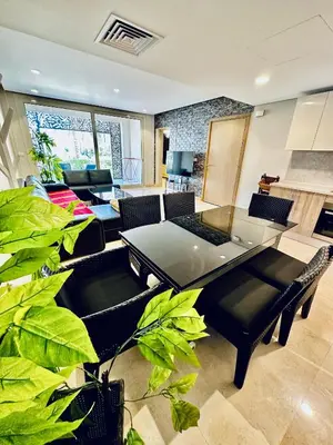 a living room with a table and some plants at 2 Bedrooms Ground Floor Pool view in Mangroovy Residence in Hurghada