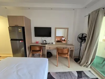 a room with a desk with a television and a refrigerator at Florenza Khamsin bird in Hurghada