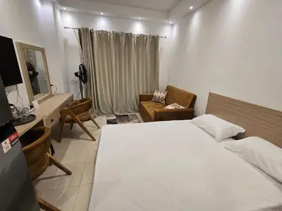 a bedroom with a bed and a desk and a chair at Florenza Khamsin bird in Hurghada