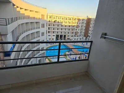 a balcony with a view of a large building at Tiba Golden Down Town in Hurghada