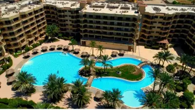 an overhead view of a swimming pool with palm trees and buildings at Palma Resort A155 Chalet Hurghada in Hurghada