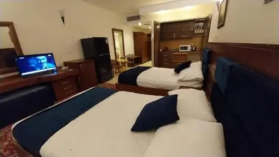 a hotel room with two beds and a television at Palma Resort A155 Chalet Hurghada in Hurghada
