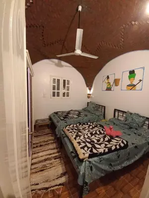 a bedroom with two beds and a ceiling at Mountain hug house in Luxor