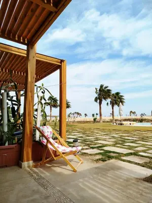 a chair sitting on a porch with palm trees at Tranquil escape in Hurghada