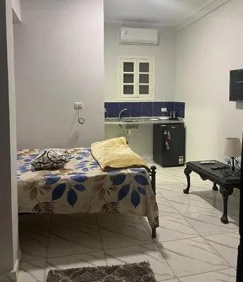 a bedroom with a bed and a sink in it at Cozy Studio on Sheraton Road near Metro Market in Hurghada