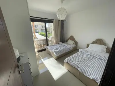 a bedroom with two beds and a window with a view at GCribs in Hurghada