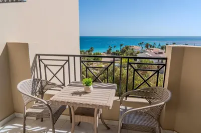 a table and chairs on a balcony with a view of the ocean at Strandapartment mit Meerblick & Pool im Juliana Beach Resort, Hurghada in Hurghada